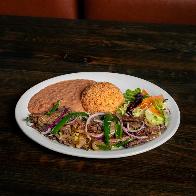 El Tarasco Restaurant Mooney's carne asada with refried beans, rice, and a side salad.